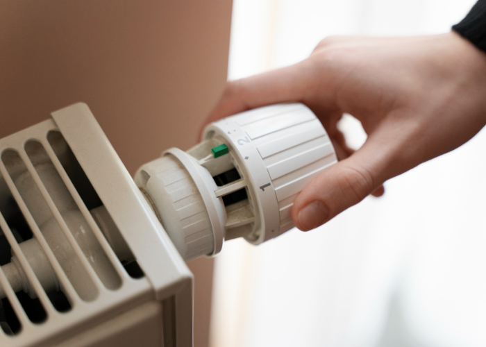 Main réglant le thermostat d’un radiateur pour améliorer le confort thermique
